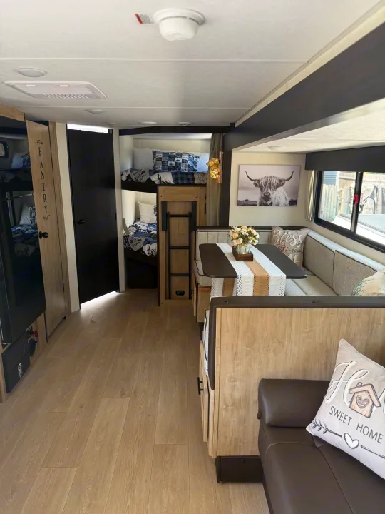 Cozy RV rental interior showcasing bunk beds, a dinette, and modern decor. Ideal for family adventures on the road.. Forest River Grey wolf 2026