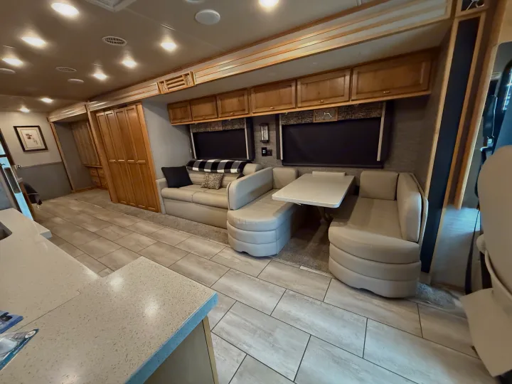 Modern RV rental interior with light tiled flooring, a comfy living area, dinette, and sleek wood cabinetry. Ready for adventure.. Tiffin Allegro 2020