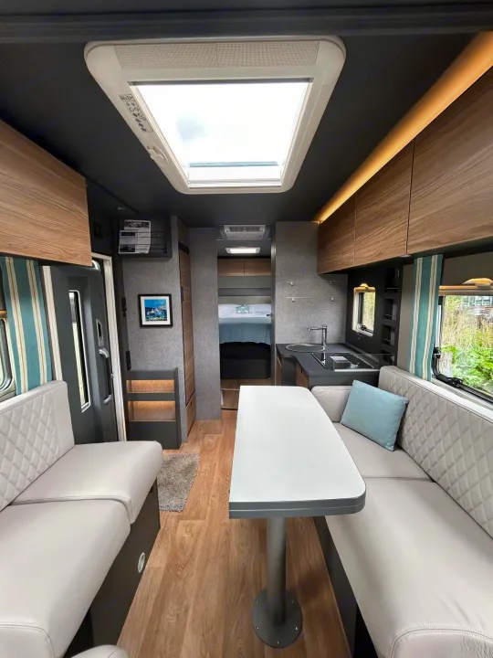 Explore this modern RV rental's inviting interior: living space, kitchen, and a cozy bedroom.. GlamperRV DBL 2026