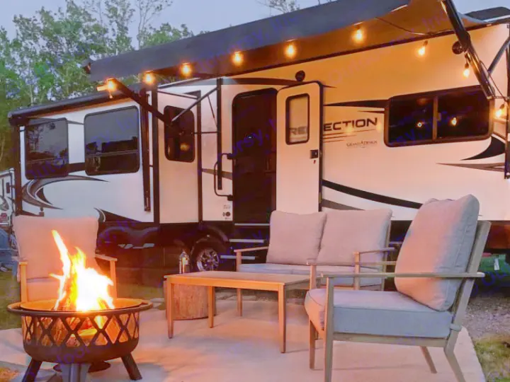 Experience cozy RV rental camping: string lights, warm campfire, and comfortable patio seating under the stars.. Grand Design Reflection 2020