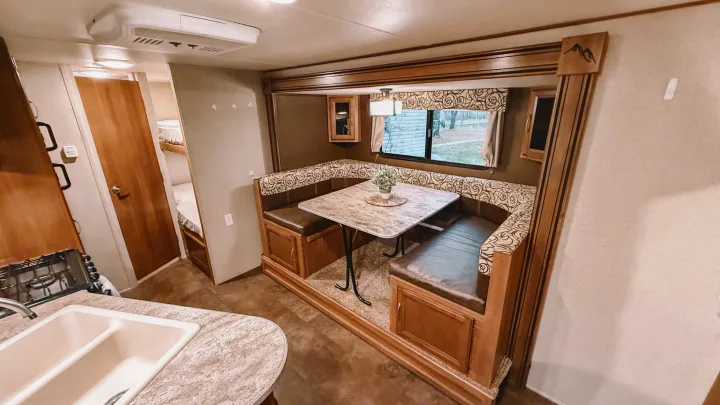 Cozy RV rental interior featuring a spacious dinette, compact kitchen, and convenient bunk beds for comfortable travel.. Coachmen Apex 2016