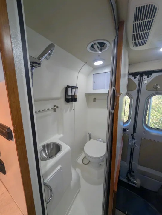 This RV rental features a compact wet bath with shower, toilet, and sink, designed for comfort in your camper.. Winnebago Travato 2018