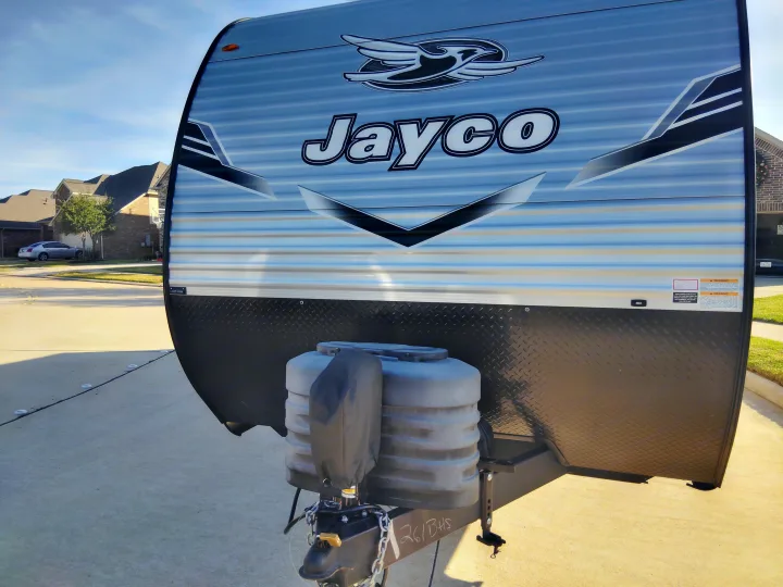 Jayco travel trailer (RV rental) front exterior, showing logo, diamond plate shield, covered propane tanks, and hitch.. Jayco Jay Flight SLX 2025