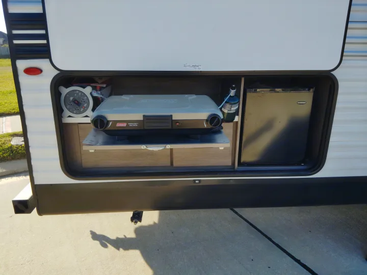 RV rental outdoor kitchen setup: Coleman grill, mini-fridge, propane, and power strip ready for camping fun.. Jayco Jay Flight SLX 2025