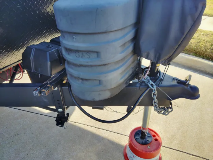 RV rental's front hitch assembly: LP gas tanks, battery box, and jack on an Andersen block, ready for travel.. Jayco Jay Flight SLX 2025