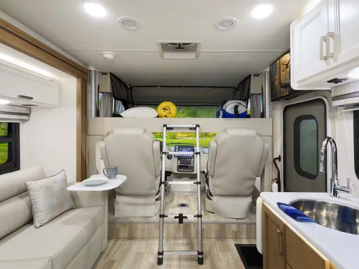 Cozy rv rental interior featuring an overhead bunk bed, comfortable seating, and a functional kitchen. Ready for travel.. Axis 24.1 2027