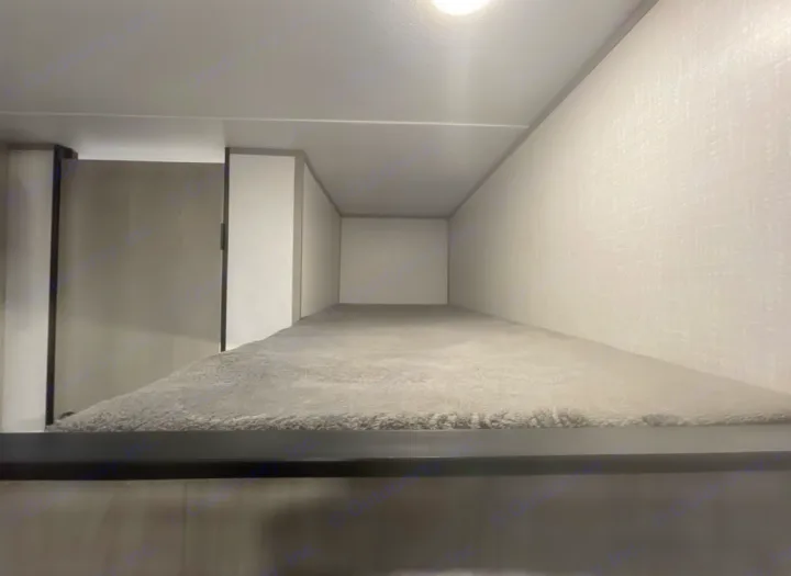 RV rental: narrow grey bunk bed with soft carpet, ideal for compact sleeping in an RV or camper.. Coleman Coleman 2023