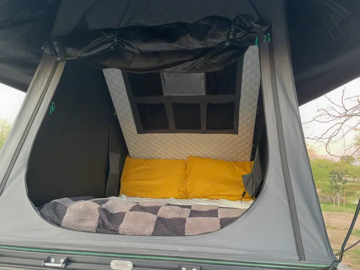 Cozy rooftop tent interior for your rv rental adventure. Plush bed with yellow pillows & quilted walls for comfort.. Mercedes Sprinter 2024