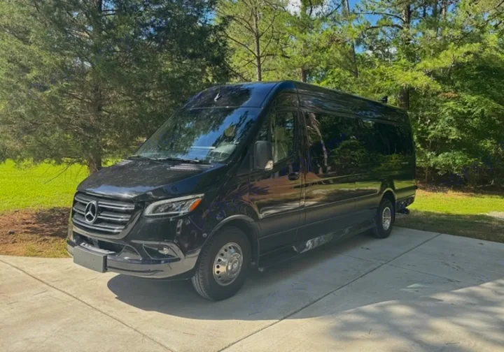Black Mercedes-Benz Sprinter van, ready for your next rv rental adventure. Parked on a sunny driveway with trees.. Ultimate Toys Ultimate Coach 2024