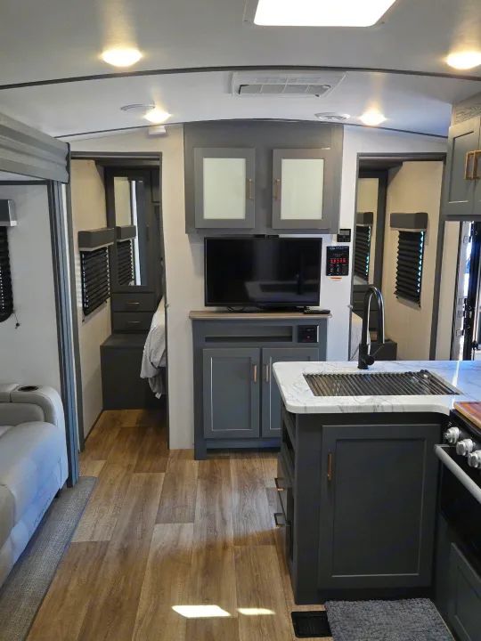 Modern RV rental interior with a cozy living space, TV area, and kitchen island, showcasing a functional and stylish layout.. Keystone Bullet 2022