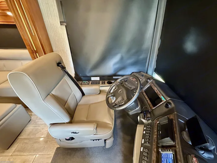 Spacious RV rental cockpit: plush driver's seat, modern dashboard, and controls for a comfortable journey.. Newmar Dutch Star 2019