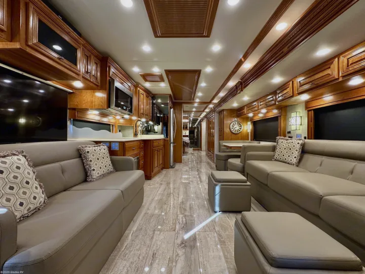 Experience comfort in this upscale RV rental living area featuring plush seating, rich wood cabinetry, and sleek flooring.. Newmar Dutch Star 2019