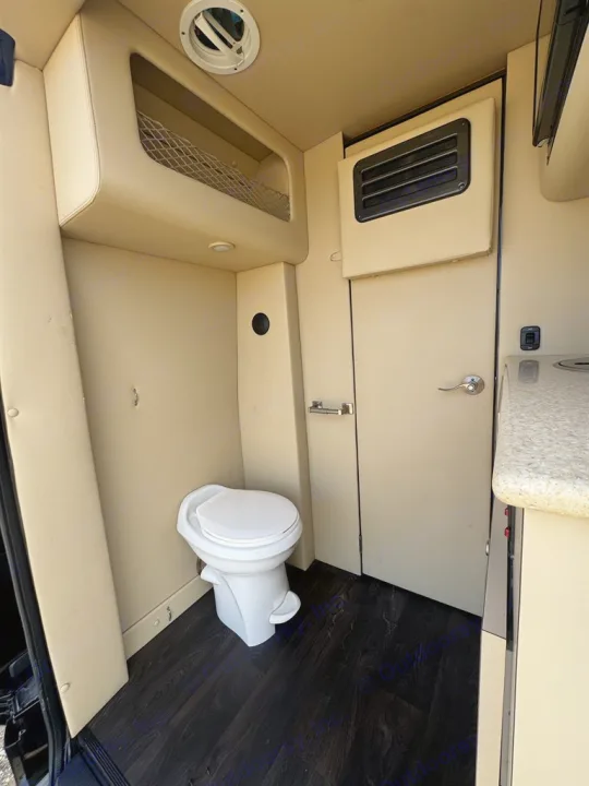 RV rental interior with a toilet, overhead net storage, and counter space, showcasing efficient van amenities.. Midwest Automotive Designs DAYCRUISER 2017