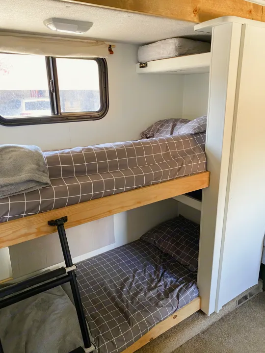 RV rental bunk beds: comfortable sleeping space with grid bedding and a window for scenic views during your travels.. Fleetwood Fiesta LX 2008
