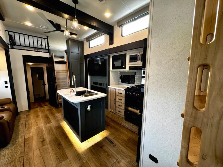 Explore this modern and spacious RV rental interior, featuring a full kitchen, living area, and loft space.. Forest River Puma Destination 2026