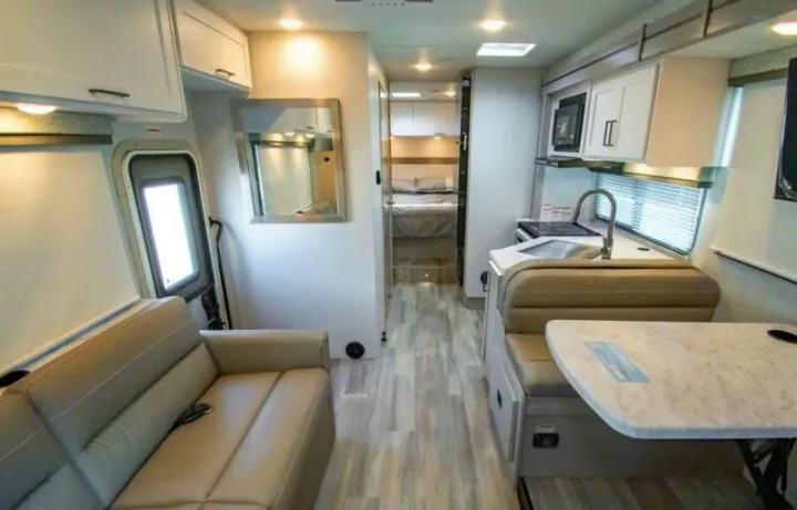 Spacious and modern rv rental interior featuring living, kitchen, dinette, and bedroom areas, perfect for your next road trip.. thor four winds 2027