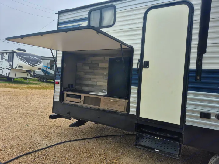 RV rental with an open outdoor kitchen featuring a fridge, sink, and counter, ideal for camping.. Crossroads 328SB 2020