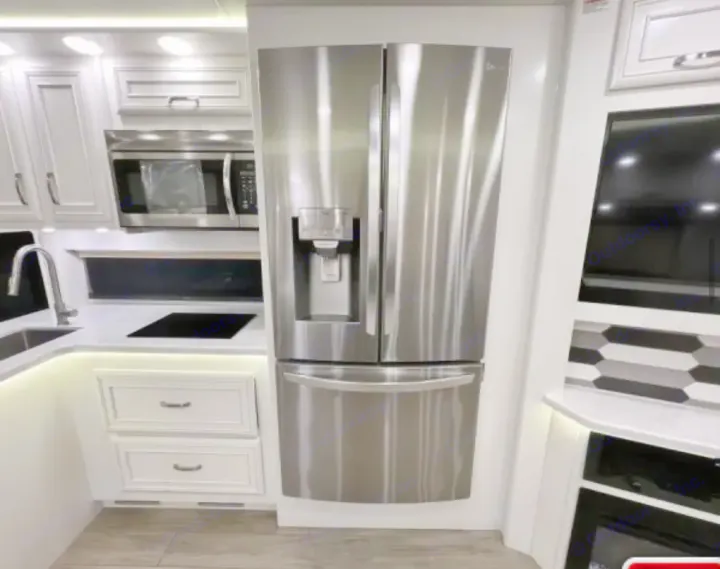 Tour this rv rental's modern kitchen! Stainless fridge, microwave, sink, and stylish white cabinetry with under-cabinet lighting.. Entegra Coach Accolade XL 2023