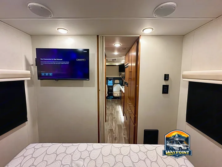 Spacious RV rental bedroom with TV showing "Not Connected," leading to kitchen/cockpit, offering modern comfort inside.. Wayfarer Wayfarer Motorhome 2019
