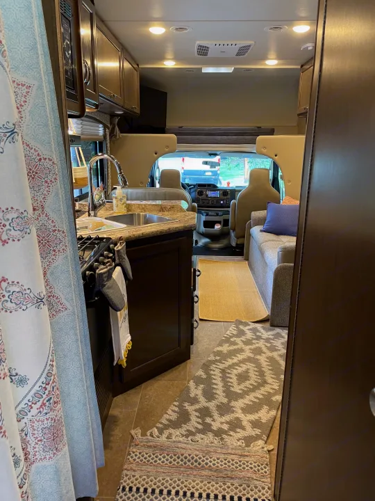 Cozy rv rental interior featuring kitchen, comfy seating, and driver's area, ready for your next road trip.. Thor Motor Coach Chateau 2017