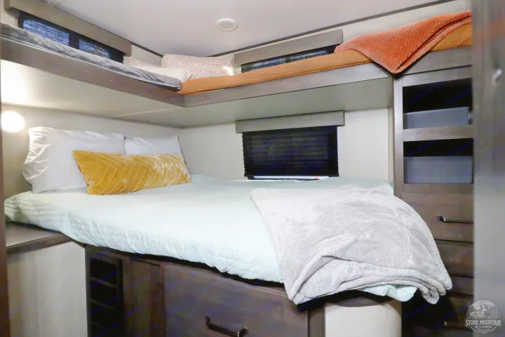 Cozy RV rental bunk bed area with soft bedding, plush pillows, and convenient built-in storage for a comfortable stay.. Grand Design Transcend Xplor 2023