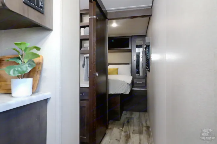 Explore this stylish RV bedroom with a comfy bed, smart storage, and modern decor, ideal for your next rv rental.. Grand Design Transcend Xplor 2023