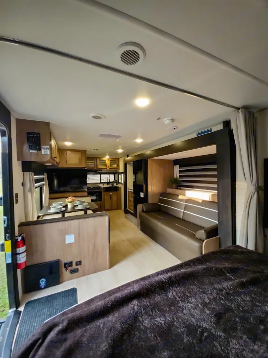 Modern rv rental interior: spacious living, dining, and kitchen areas, plus a cozy sofa. Perfect for travel.. Forest River Cherokee Grey Wolf 2025