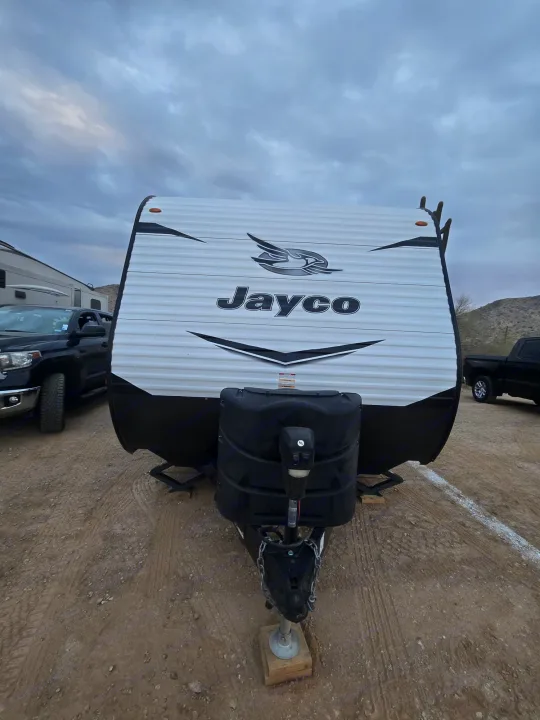 Jayco travel trailer RV rental parked on a dirt lot, ready for your next outdoor adventure under cloudy skies.. Jayco Jay Flight SLX 2022