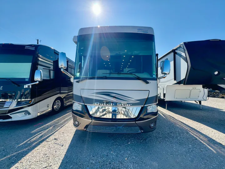 A prominent Newmar Dutch Star RV, likely an rv rental, is parked between another RV and a fifth-wheel trailer on a bright day.. Dutch Star Dutch Star Motorhome 2017