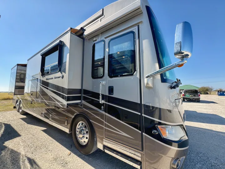 This luxury Newmar Dutch Star RV rental gleams in the sun, parked on a gravel lot, ready for adventure.. Dutch Star Dutch Star Motorhome 2017