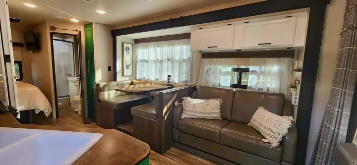 Spacious RV rental interior featuring a comfy dinette, sofa, kitchen, bedroom, & bathroom. Perfect for travel adventures.. Jayco Redhawk 2017