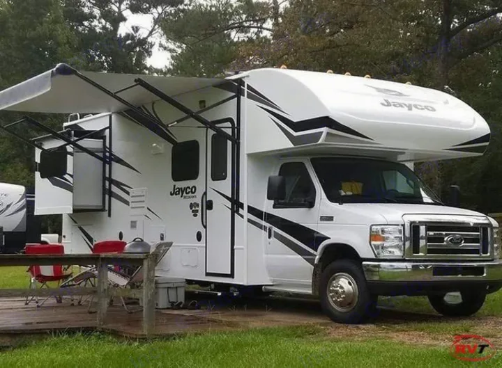 White Jayco Class C RV rental, with awning and slide-out extended, parked at a grassy campsite, ready for adventure.. Jayco Redhawk 2019