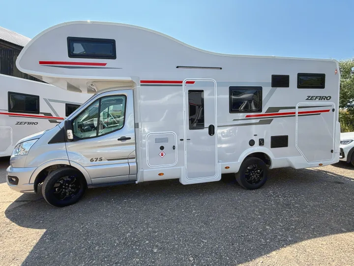 A sleek Zefiro 675 rv rental, a white and silver motorhome, is parked outdoors on a sunny day.. Rollerteam Zefiro 675 2026