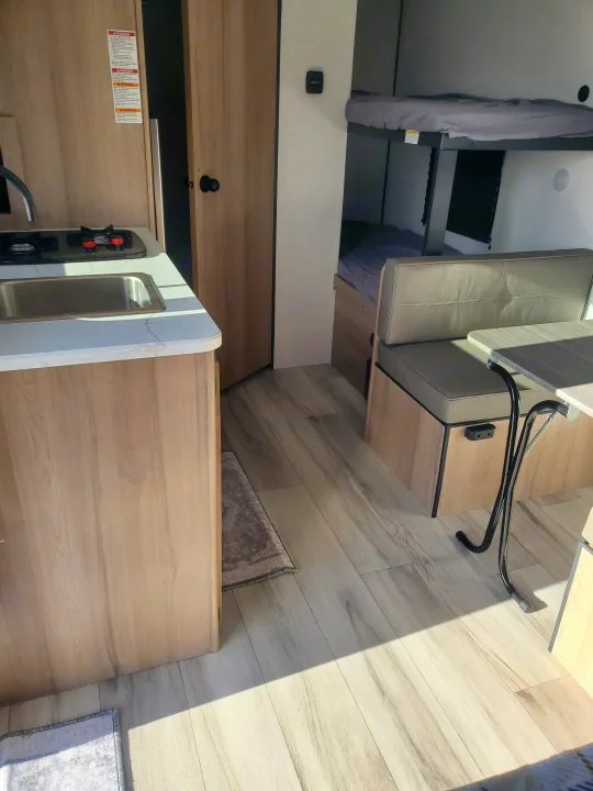 Cozy RV rental interior featuring a kitchenette, dinette, and bunk beds, perfect for family adventures.. Keystone Coleman 2026