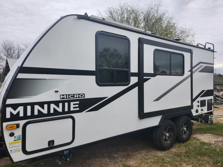 Modern white Winnebago Micro Minnie travel trailer with black accents, perfect for your next RV rental and camping adventure.. Winnebago Minnie Winnie 2025