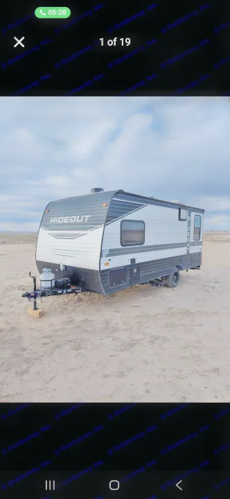 Experience outdoor adventures with this Hideout travel trailer rv rental, parked on a vast, open field under a cloudy sky.. Keystone RV Hideout 2022