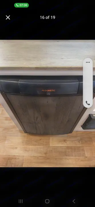 RV rental interior: Dometic refrigerator with a wood-grain panel door, integrated into a light countertop and wood floor.. Keystone RV Hideout 2022