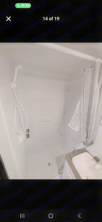 Compact RV rental bathroom featuring a white shower stall with handheld showerhead, and a small sink vanity.. Keystone RV Hideout 2022