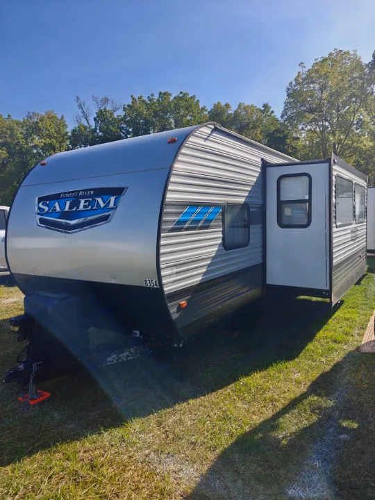 Forest River Salem travel trailer, perfect for rv rental. Silver & black, door open, on sunny grass, sunny day.. Salem 36VBDS 2021