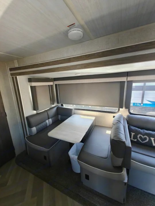 Cozy RV rental dinette with L-shaped seating, a table, and modern grey decor. Ideal for relaxing and meals.. Salem 36VBDS 2021