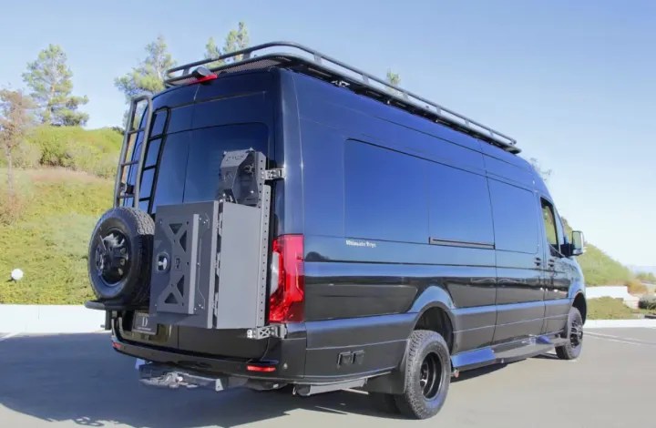 Black custom Sprinter luxury RV van with roof rack, ladder, rear tire, and storage box, perfect for an RV rental adventure.. Ultimate Toys Ultimate Presidential 2020