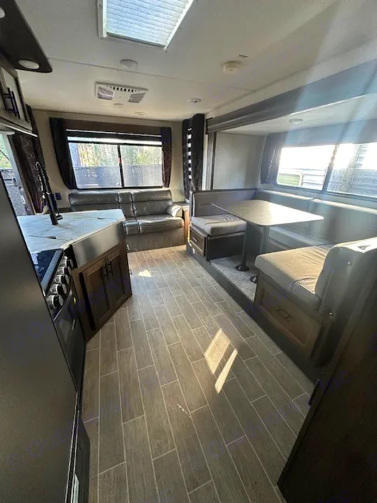 Explore this modern rv rental interior! Featuring a cozy sofa, full kitchen, and dinette for family meals and relaxation.. Forest River Cherokee Grey Wolf 2020