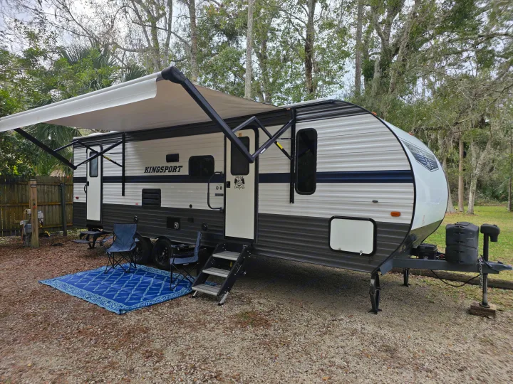 Enjoy this Kingsport travel trailer RV rental! Perfect for camping, it features an extended awning, outdoor mat, and chairs.. Gulf Stream Kingsport 2022