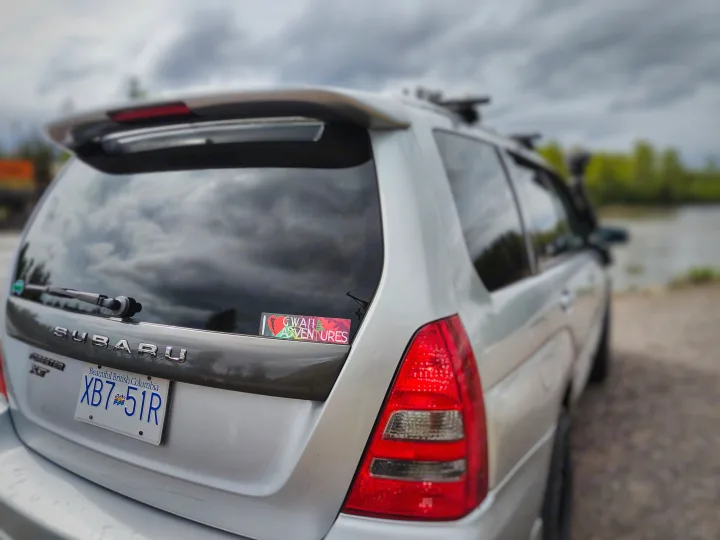 Silver Subaru Forester XT, roof rack, parked by water. This adventure vehicle offers versatile travel akin to an RV rental for BC explorations.. Subaru Forester 2007