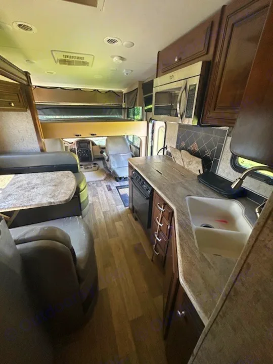 Well-equipped rv rental interior: kitchen with sink, dinette, and cozy overhead bed. Adventure awaits!. Thor Outlaw 2017