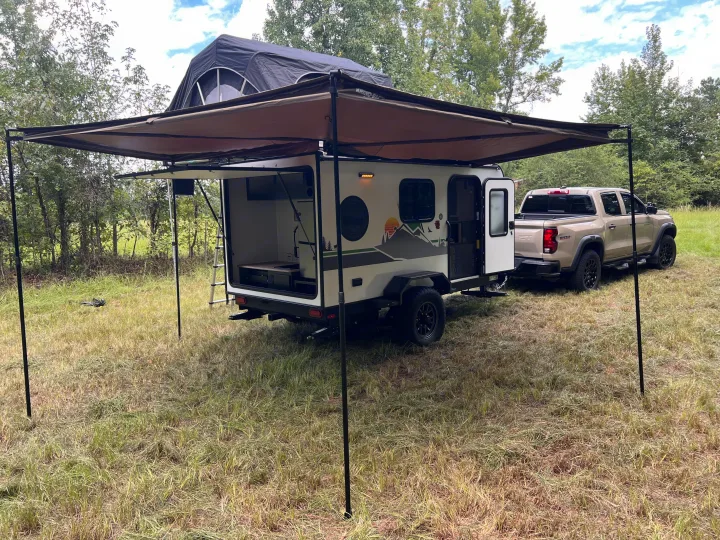 An off-road teardrop trailer with an open galley and rooftop tent, pulled by a pickup, ideal for an rv rental outdoor adventure.. Forest River NoBo 10.7 2024