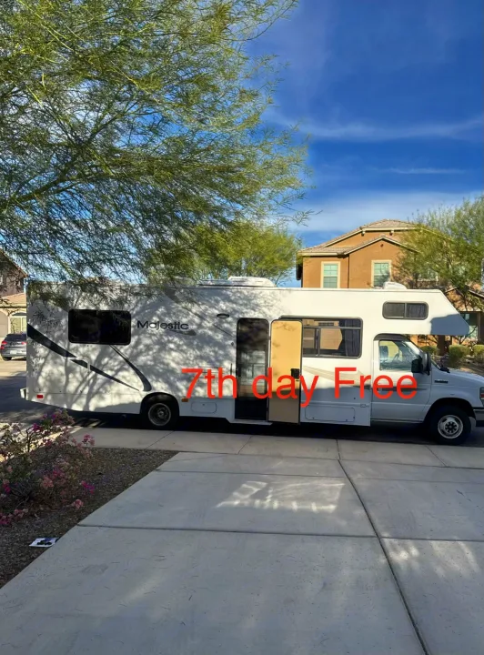 Spacious white Majestic RV rental parked on a sunny driveway, offering 7th day free. Perfect for your next trip!. Thor Majestic 2013