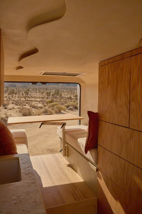 RV rental interior: light wood, pull-out table, sculpted ceiling, and a panoramic desert view with Joshua trees.. Dodge Ram 1500 2021