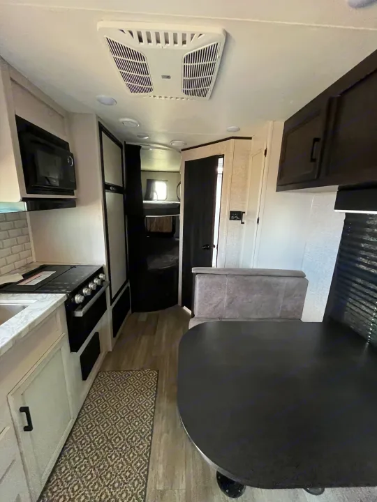 This modern rv rental features a well-equipped kitchen, dining area, and bunk beds, offering a cozy interior.. Jayco Jay Flight SLX Rocky Mountain Edition 2022