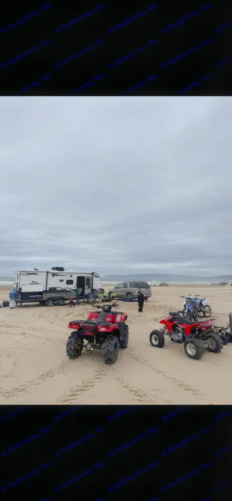 An RV rental, SUV, and ATVs are parked on a wide sandy beach under a cloudy sky, set for outdoor adventures.. Jayco Jay Flight SLX Rocky Mountain Edition 2022